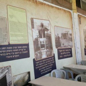 (PHOTO: A copy of the 1807 deed and other historic photos are displayed on the walls of the empty Mitzpe Shalhevet building. Temporary tables and chair are set up for the Shabbat Chayei Sarah weekend.)